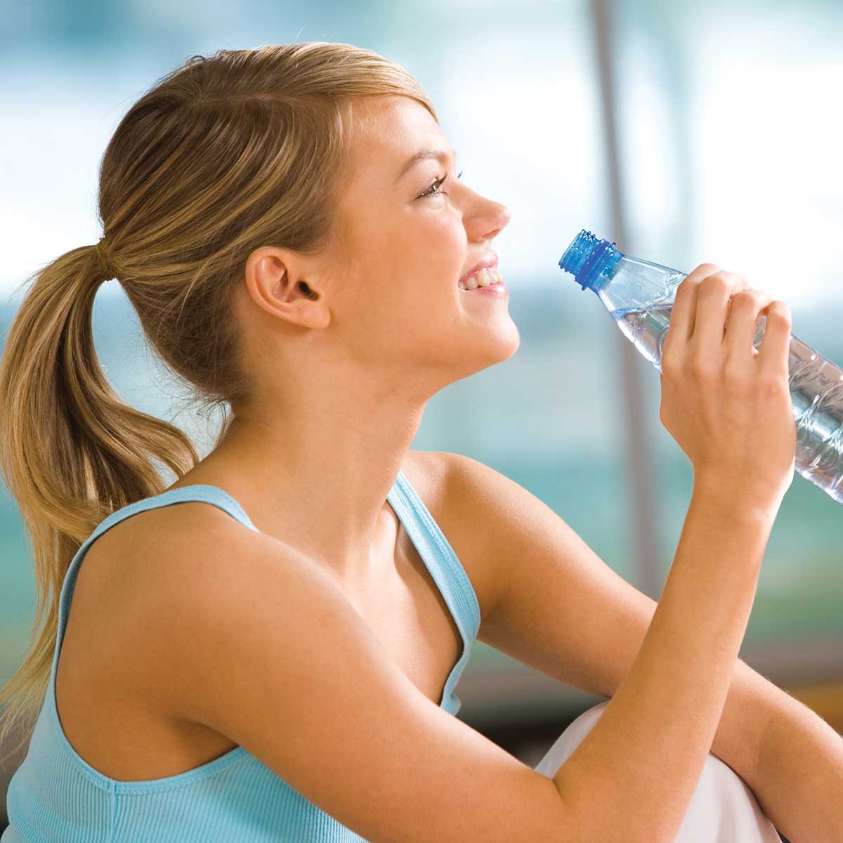 Young woman drinking water to stay hydrated